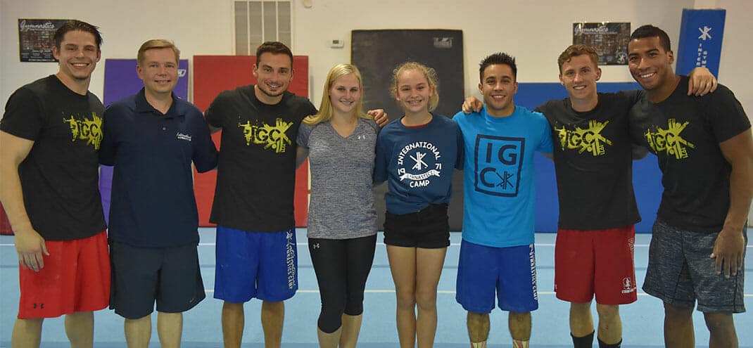 group of gymnasts at International Gymnastics Camp smiling at camera and standing side by side