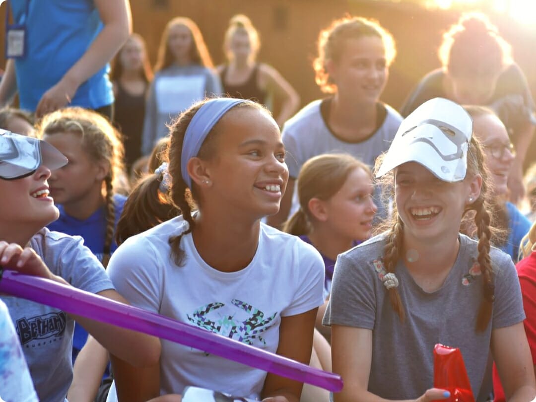 girls smiling and sitting on the bleachers