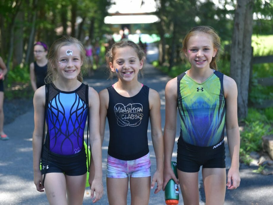 three girls in leotards posing for a photo
