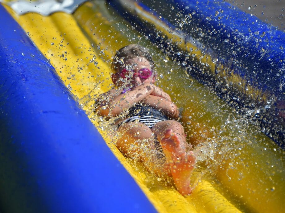 camper sliding down the water slide wearing goggles