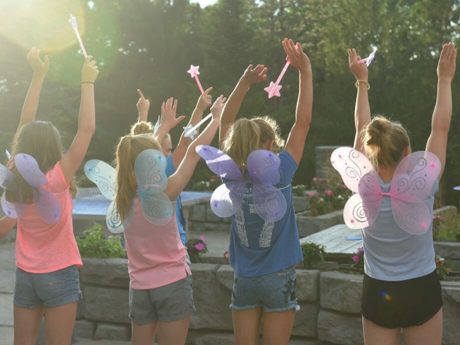 girls facing away wearing fairy wings with star wands