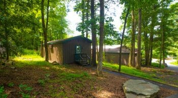 exterior shot of a cabin situated in a wooded area of the camp