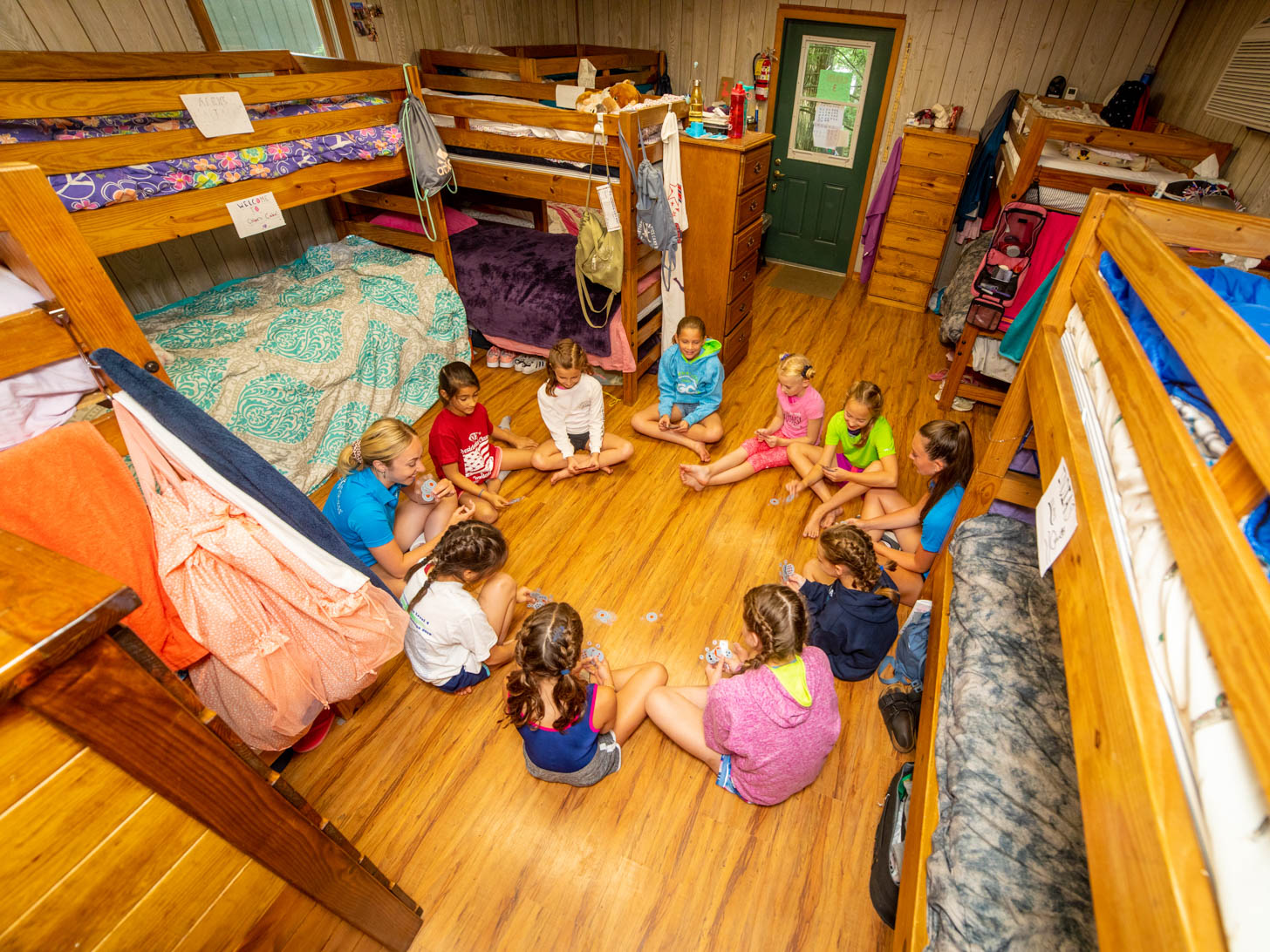counselors and campers sitting in a circle on the floor of one of the cabins
