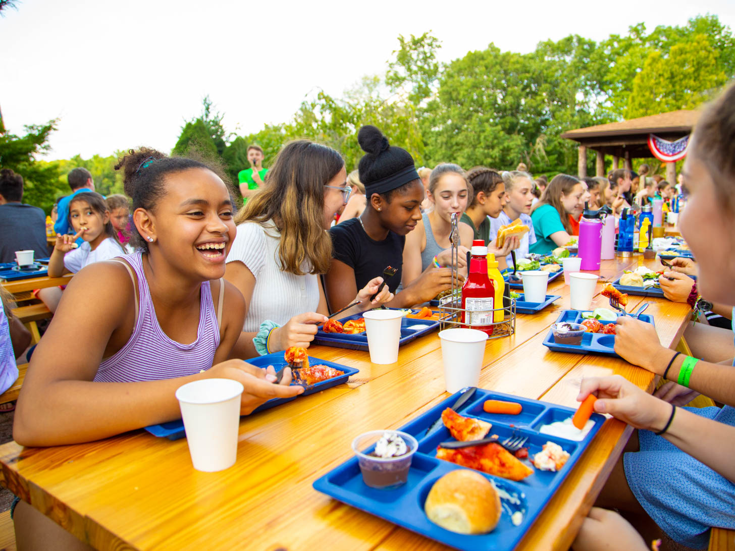 group of young girls eating at picnic tables