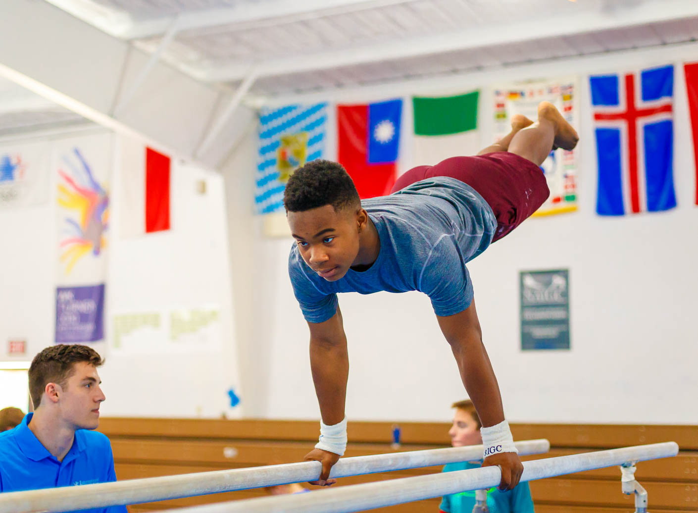 camper being coached on the parallel bars