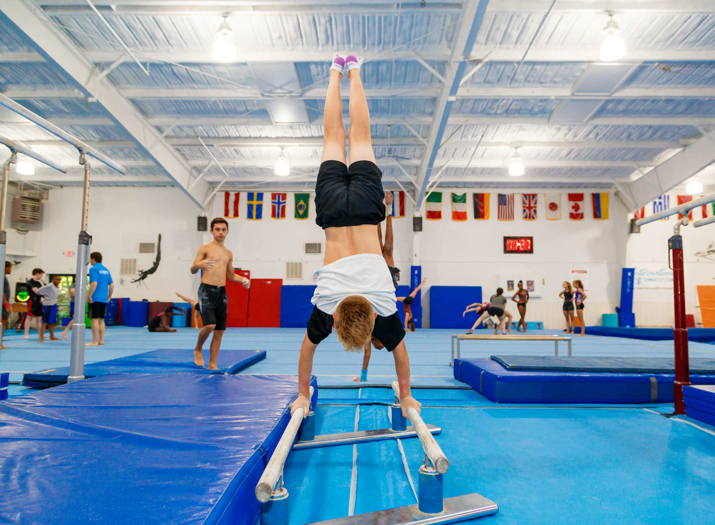 boy upside down on parallel bars