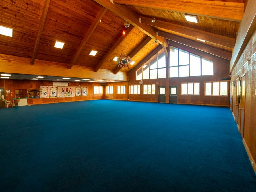 the wide open floor gym with log cabin style ceiling