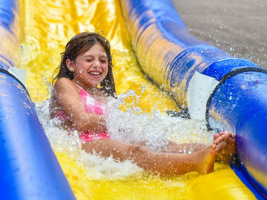 younger camper sliding down the water slide