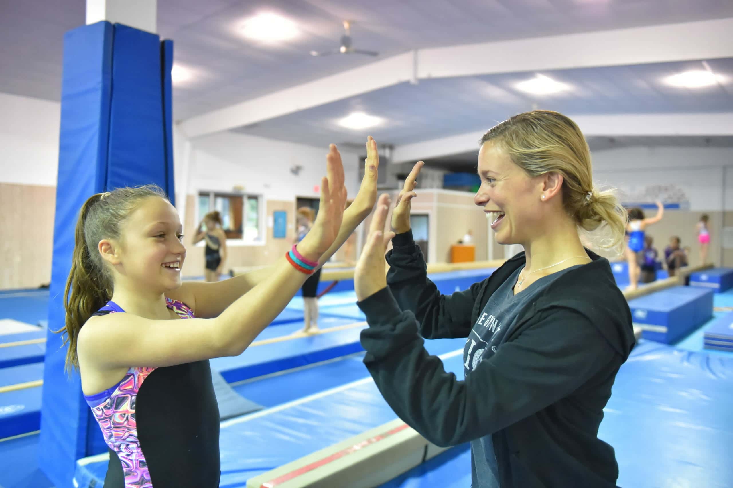 coach and gymnast high fiving