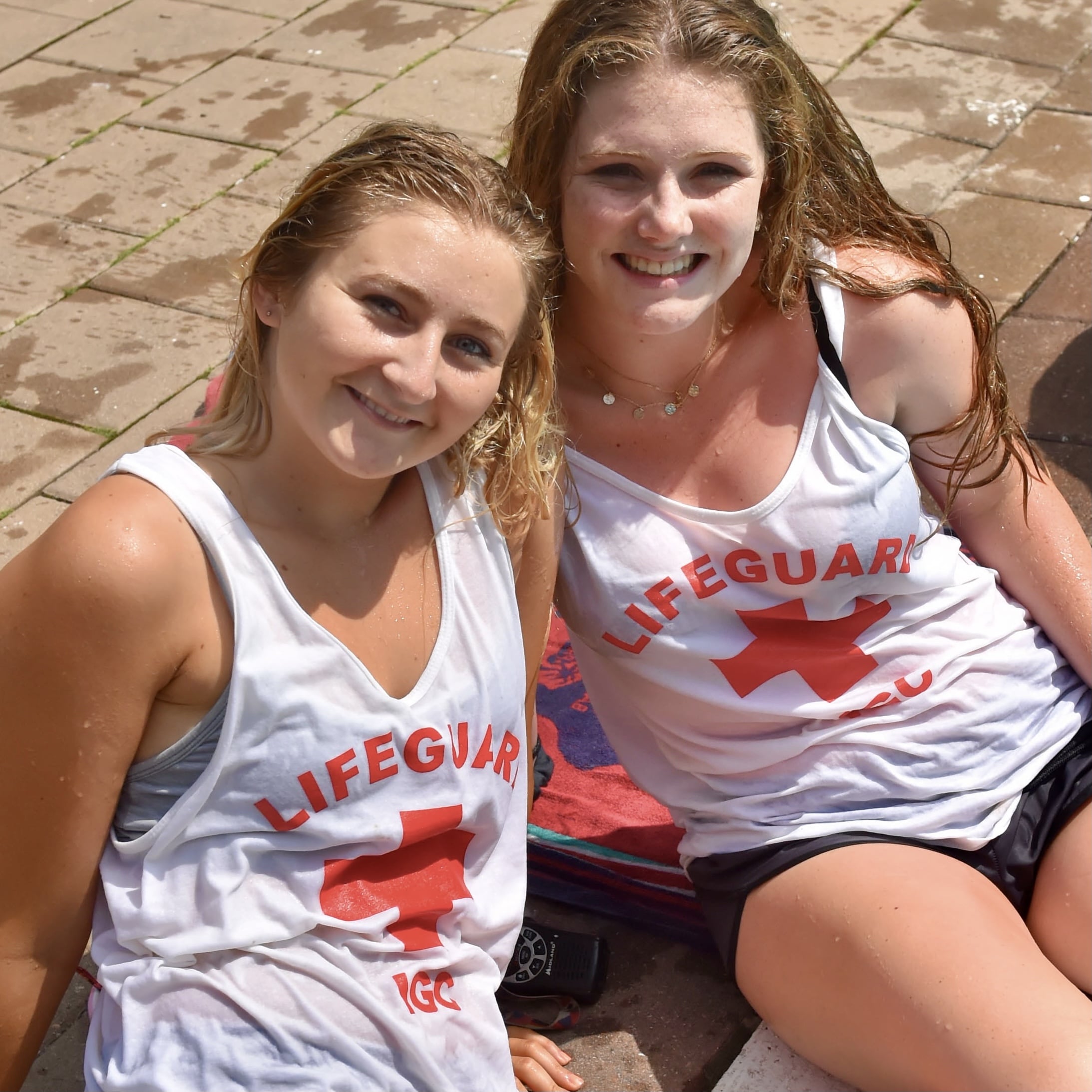 two female lifeguards sitting and smiling for photo