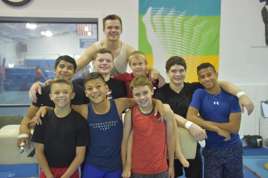 Group of boys with staff member smiling for photo