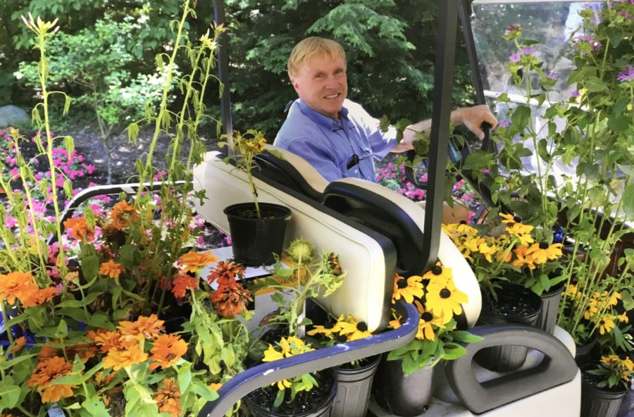 Bruno Klaus on his golf cart filled with flowers and plants.