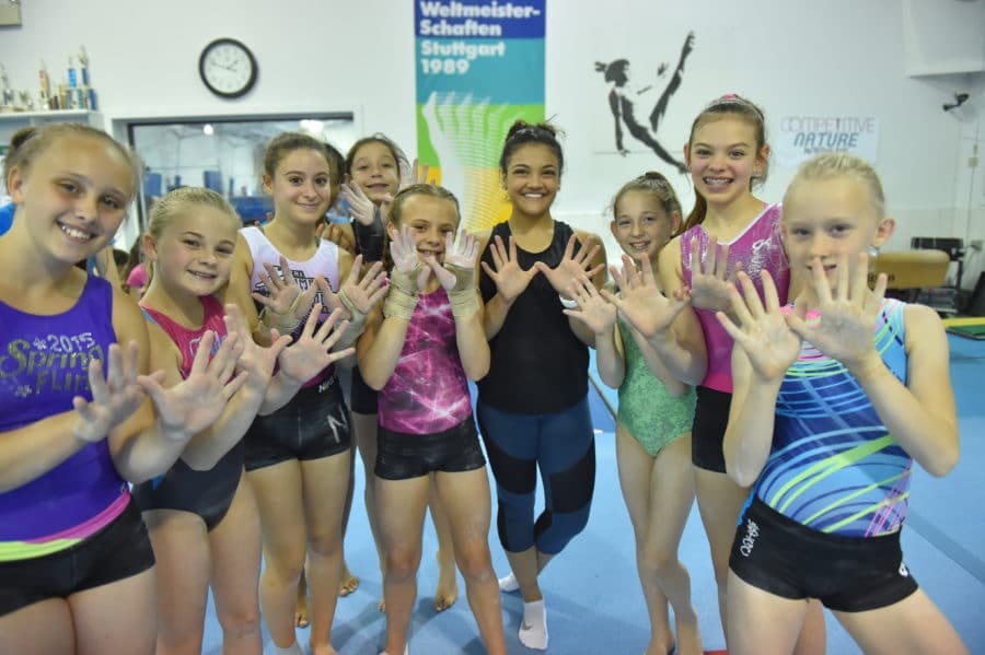Laurie Hernandez with IGC campers showing the Kount on Kindness hands.