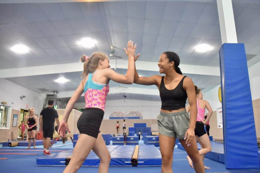 coach and gymnast high-fiving